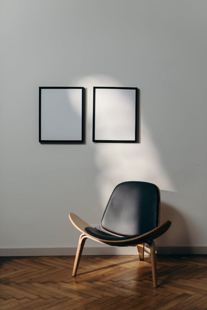 pexels photo 4067759 Stylish minimalist interior with black chair and blank frames casting shadows.