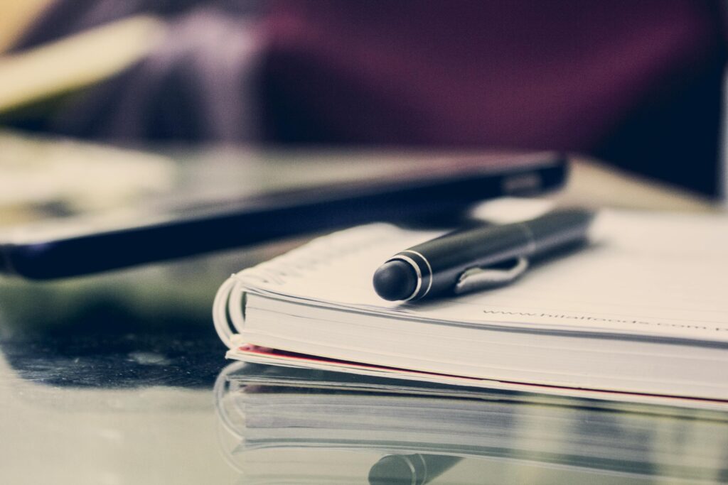 pexels photo 891059 891059 Close-up of an elegant pen resting on an open notebook in a stylish office environment.