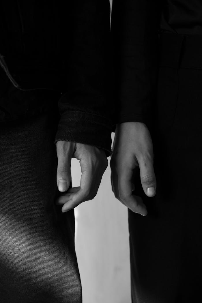 about-us Elegant black and white photo of two touching hands, symbolizing connection and intimacy.